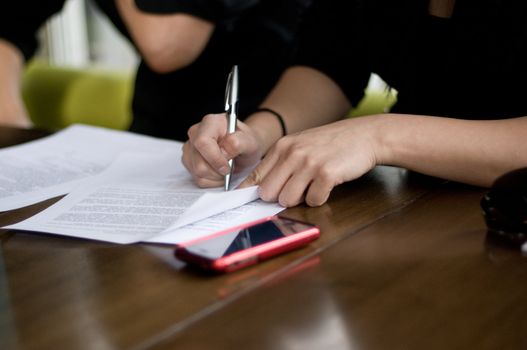 a business women signing a contract at the end of the meeting