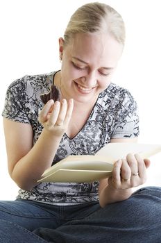 Girl reading a funny book and eating chocolate biscuit