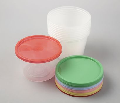 Round plastic container with coloured plastic cover.