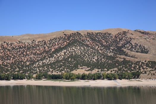 Lovely lake and blue sky contrasts with brown Utah hills.