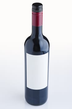 Red wine bottle with empty label over white background