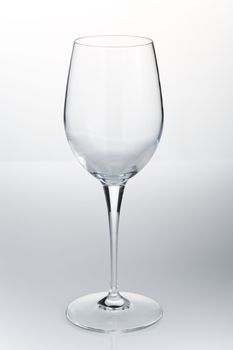 Empty red wine glass on the white reflective table