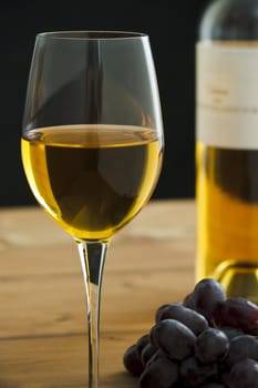 Wine glass with bottle and grapes on the table