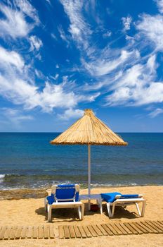 couch and sunshade on the seaside and sky with clouds