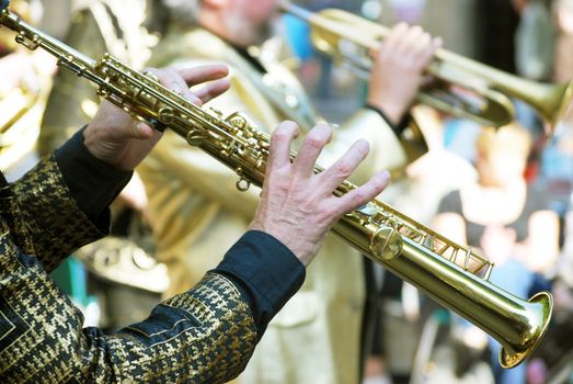 Two jazz musicians entertain public in busy city street.