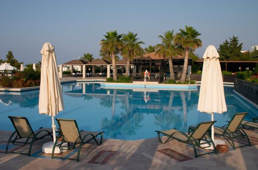 couch and sunshade near of a swimming pool in resort