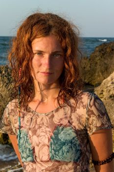 portrait of redheaded hippy girl against of sea