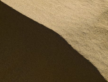 Abstract image showing detail of sand dunes in light and shadow at Golden Bay in Malta