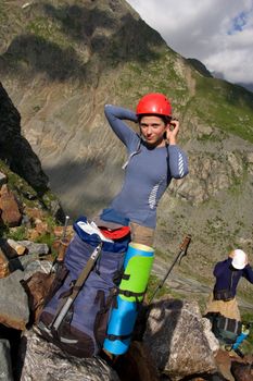 Couple of alpinist getting on helmets in mountain