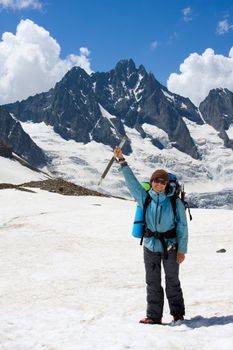 Smiling girl with ice-axe on glacier at Caucasus mountains