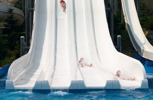children competition on the waterslide in aquapark
