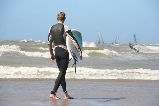 Scheveningen Surf Competition: Surfer with his surfboard walking into the surf