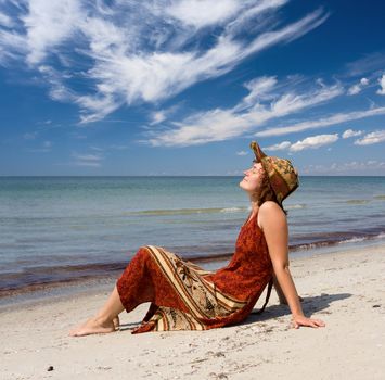Girl in dress become sunburnt at sand sea coast