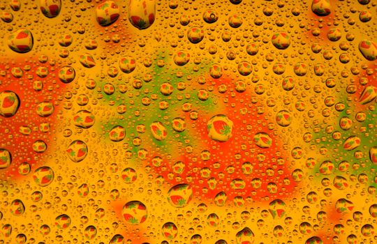 Water drops over strawberries background (close-up photo)