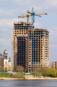 Cranes building the house on the coast