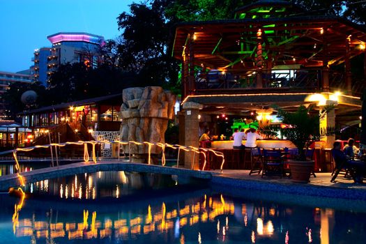 Night time photo of a swimming pool and cafe in resort.