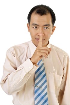 Silence sign with Asian businessman finger near lips on white background.