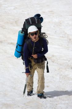 exhausted extreme tourist climbing on snowy mountain
