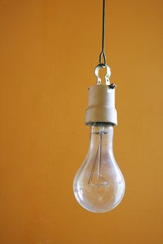 The old bulb hangs on an orange background
