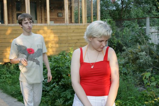 The man wishes to present a red flower to the girlfriend 