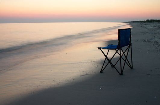 Loneliness camp-chair on the sea shore at the time of sunshine