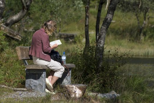 Naturally looking lady in a park studying a book!