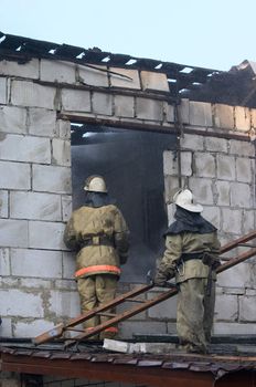 fireman with step ladder near of house on fire