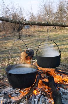Boiling water in pots above the fire