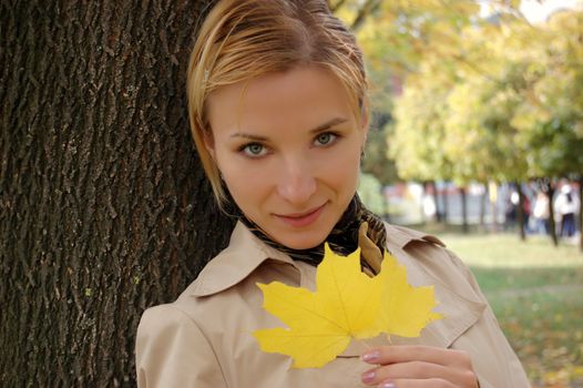 autumn girl portrait outdoors with yellow leaf