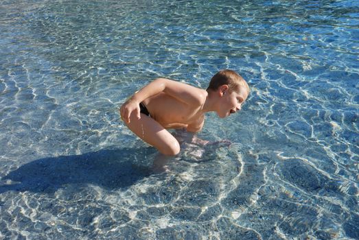 a boy is smiling and playing in a water