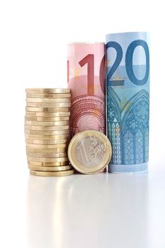 three euro rolled bills with one euro coin isolated on white background