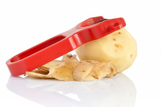 plastic potato pealer with one  peeled potato isolated on white background