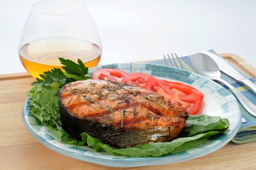 Grilled salmon steak served with fresh vegetables.