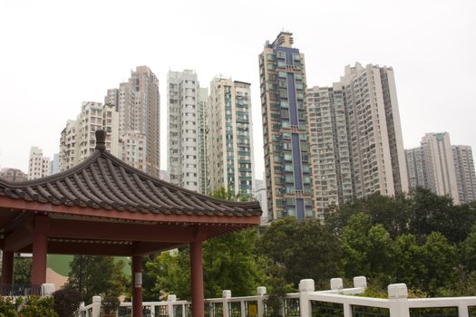 It is chinese style park in the city and some morden house building behind it.