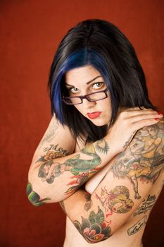 Pretty young woman with many tattoos crossing her arms