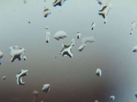 Abstract background design of raindrops forming on a window pane.