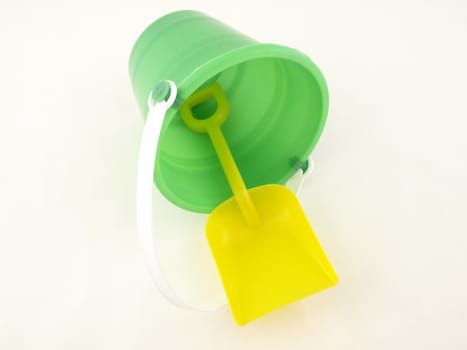 A plastic bucket and shovel laying on its side isolated on a white background