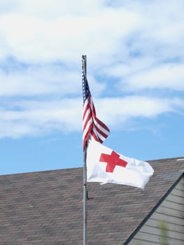 United States and Red cross flags blowing in the wind