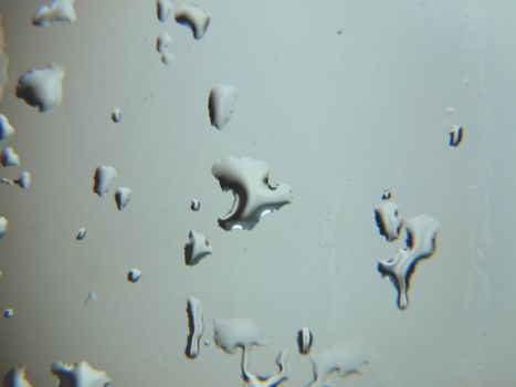 Abstract background design of raindrops forming on a window pane.