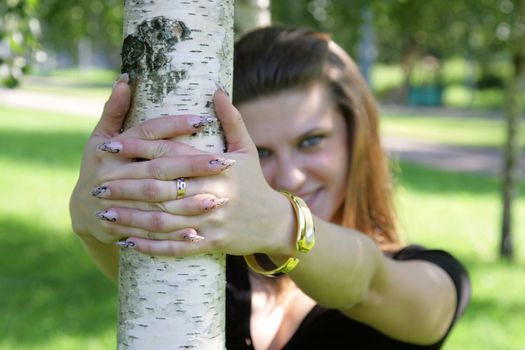 The blue-eyed girl looks out because of a tree