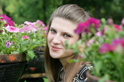 Portrait of the beautiful girl among blossoming plants