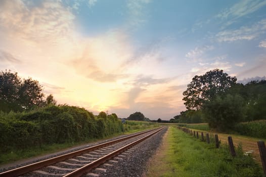 rail way tracks in a rural scene with a nice pastel sunset