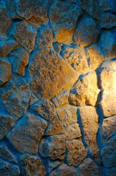 old-style wall of wild stones with decorative lighting