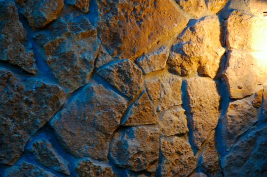 old-style wall of wild stones with decorative lighting