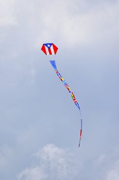 Airborne kite with Puerto Rican flag printed on body, and flags of other Latin American countries forming a long tail.