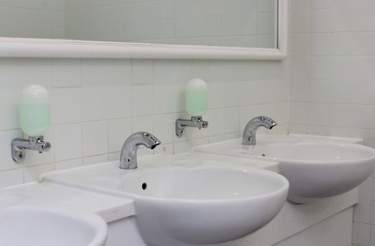 Public empty restroom with washstands and mirror