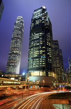 Skyscraper with traffic light and cars motion blurred in Hong Kong