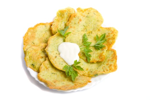 close-up pancake from marrow with parsley on plate, isolated over white background