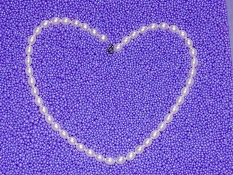 The image heart from pearls beads on a lilac background