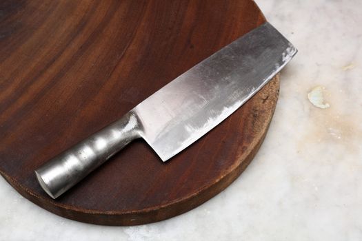 Closeup image of chinese kitchen knife on cutting board.